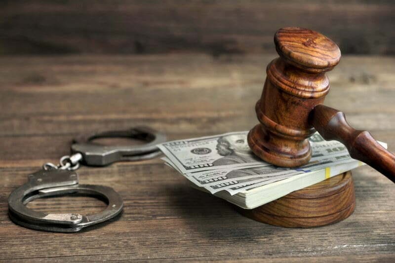 money handcuffs and gavel on table