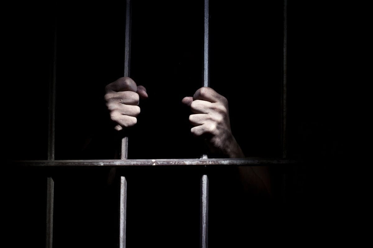 man holding jail bars